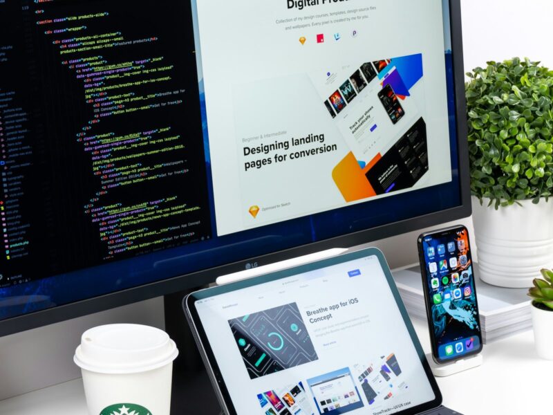"Moderner Arbeitsplatz mit Bildschirm, Tablet und Smartphone, der digitalisierte Beratungsarbeit veranschaulicht."